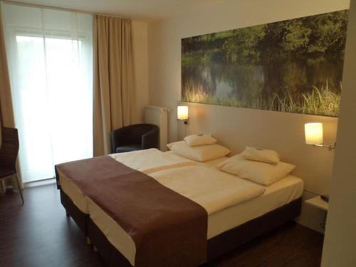 弗伦登贝格达斯纽公园酒店的一间卧室配有一张壁画大床