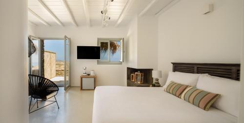 凯勒里瓦迪The Summit of Mykonos的白色卧室设有一张大床和电视。