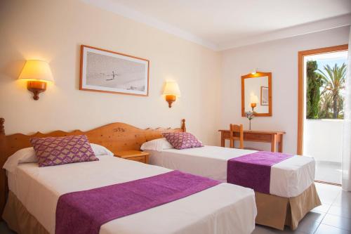 卡拉达沃Inturotel Azul Garden的酒店客房,设有两张床和镜子