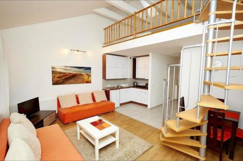 库瑞尼卡慕斯卡Apartamenty Międzymorzem的客厅配有橙色沙发和楼梯