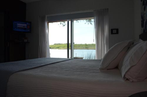新帕尔米拉波萨达埃尔纳奇柔尔酒店的一间卧室设有一张大床和大窗户