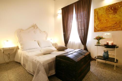 彼得拉桑塔La Piccola Atene的一间卧室配有一张带白色床罩的床和窗户。