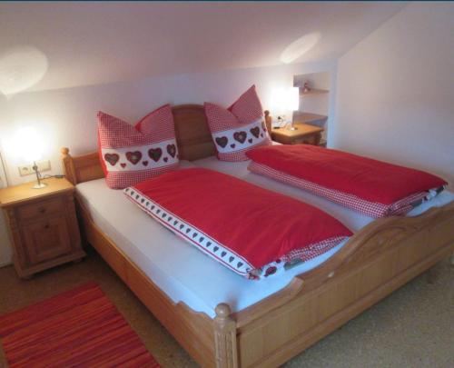 阿尔戈伊地区伊斯尼Ferienwohnung Steible的卧室配有一张大床,提供红色床单和枕头