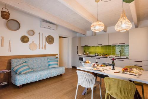 比比翁Lino delle Fate Eco Resort的厨房以及带蓝色沙发的客厅。