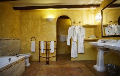 马纳科尔拉雷塞尔瓦罗塔纳酒店的带浴缸、两个盥洗盆和卫生间的浴室