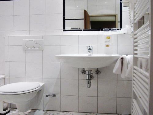 美因河畔法兰克福Motel Frankfurt的白色的浴室设有水槽和卫生间。