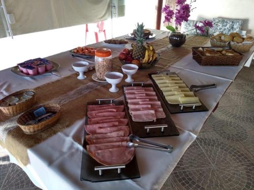 瓜鲁雅伯南布哥太阳酒店的一张带肉类和奶酪自助餐的桌子