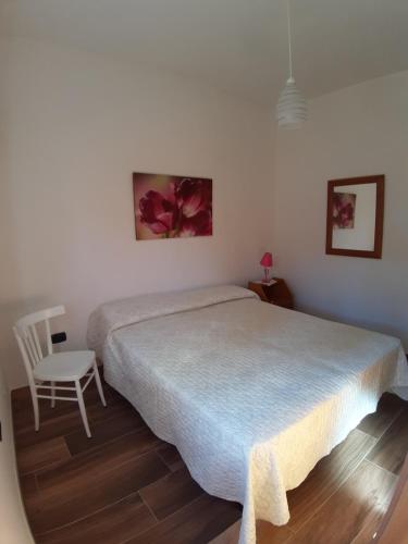 帕拉比塔Casa vacanza nel cuore del Salento的一间卧室配有一张大床和一把椅子