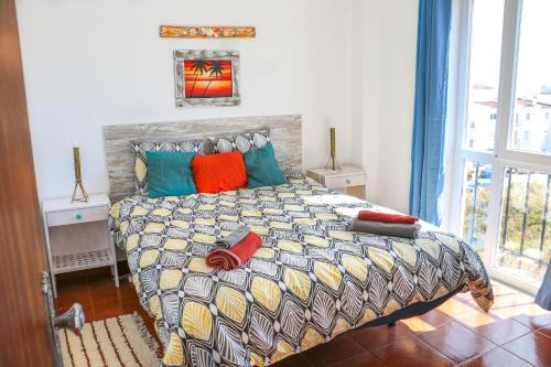 卢斯Casa Bambu Luz的一间卧室配有一张带色彩缤纷枕头的大床