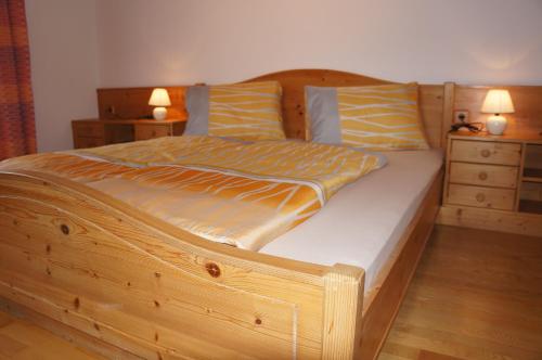 列兴Ferienhaus Bergwelt的卧室内的木床,带2个床头柜