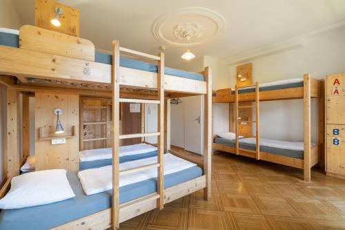 因特拉肯Chalet Hostel @ Backpackers Villa Interlaken的宿舍内带四张双层床的房间