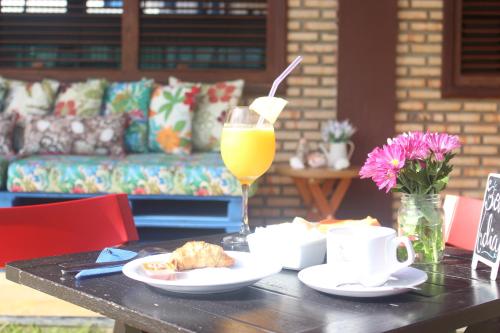 特赖里Pousada Dona Santinha的一张桌子,上面放着一杯橙汁和一杯饮料