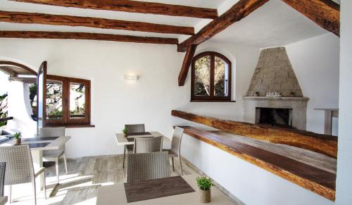 圣特雷莎加卢拉Villa Elena B&B experience的客房设有壁炉、桌子和椅子。