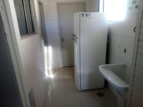 坎波斯杜若尔当Apartamento no Centro de Campos do Jordao的带水槽的浴室内的白色冰箱