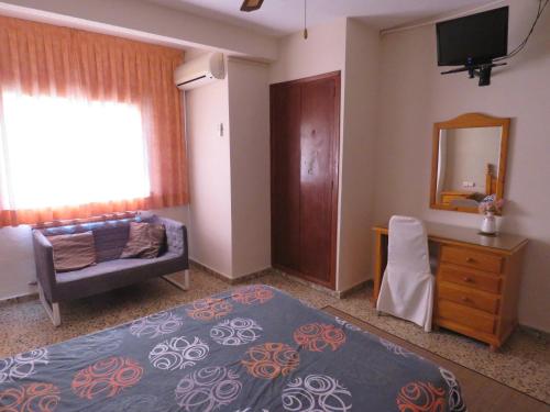 西利亚阿兰酒店的一间卧室配有一张床、一张沙发和一面镜子