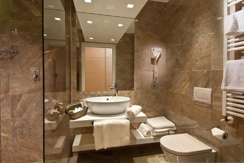 里乔内Hotel Sarti的一间带水槽、卫生间和淋浴的浴室