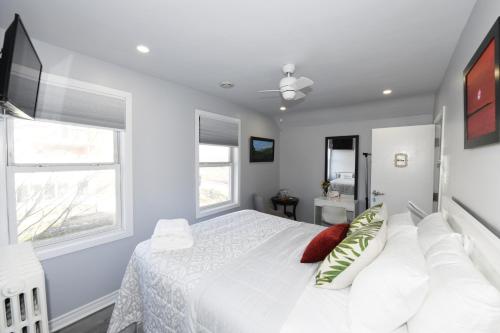 尼亚加拉瀑布Serene Niagara Inn的白色卧室设有白色的床和2个窗户