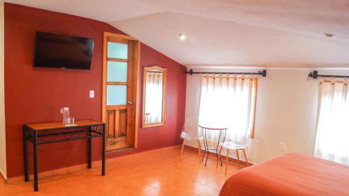 圣克里斯托瓦尔-德拉斯卡萨斯Hotel Casa Margarita的卧室配有一张床和一张桌子及椅子