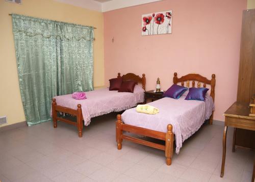 圣萨尔瓦多德朱Lo de Margarita的一间卧室设有两张床、一张桌子和一个窗口