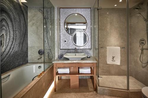 香港香港湾仔帝盛酒店的一间带水槽、浴缸和镜子的浴室