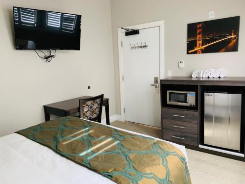 旧金山海湾酒店的一间卧室配有一张床、一张书桌和一台电视。