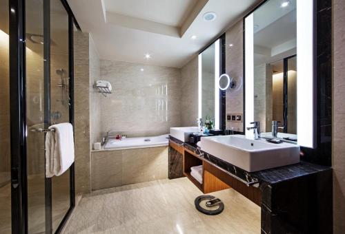 南昌南昌瑞颐大酒店的浴室配有盥洗盆和浴缸。