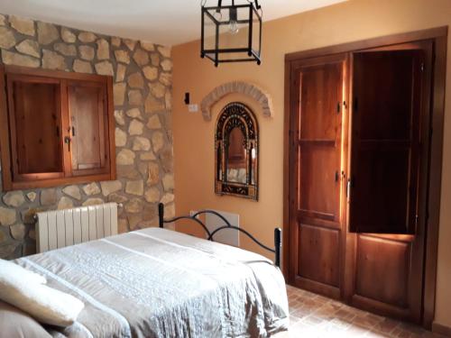 卡斯特里尔Casita Vista Alegre的一间卧室设有一张床和石墙