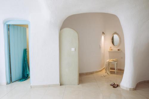阿克罗蒂里SantoCaves的一条带白色墙壁和蓝色门的走廊