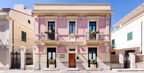 雷焦卡拉布里亚Villa Lavinia的粉红色的建筑,设有两个阳台和门