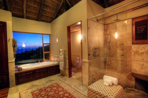 阿尔弗雷德港奥希阿纳海滩及野生动物保护区山间小屋的大型浴室设有浴缸和淋浴。