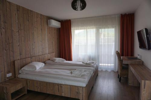 Sasca RomânăPensiunea Patru Anotimpuri的一间卧室设有一张大床和一个窗户。