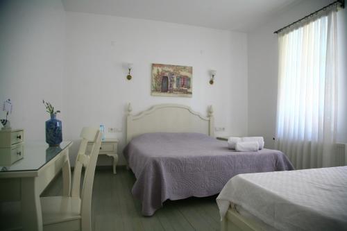艾瓦勒克Gule Cunda的一间卧室设有两张床、一张桌子和一个窗口。