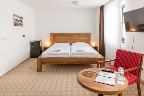 派克波特斯耐兹库鲁克尼布达酒店的卧室配有1张床、1张桌子和1把椅子