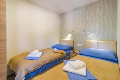班约勒Centinera Deluxe Mobile Homes的配有两张床铺的客房提供蓝色的床单和毛巾