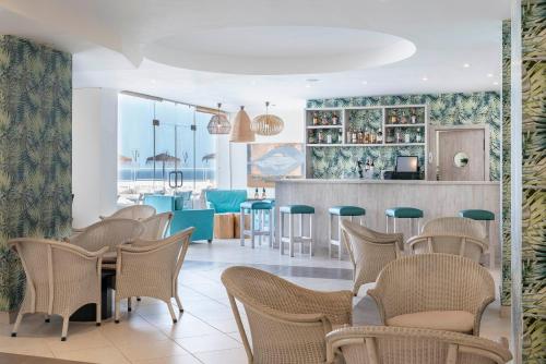 圣米格尔德阿沃纳Hotel Tenerife Golf & Seaview的一间带桌椅的餐厅和一间酒吧