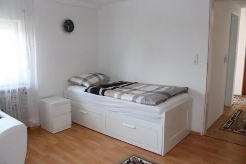 MörlenbachFerien- und Monteurwohnung Julia的白色墙壁的客房内的一张小床