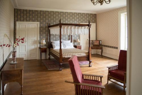 DangéChâteau de Piolant的卧室配有1张床、1张桌子和1把椅子