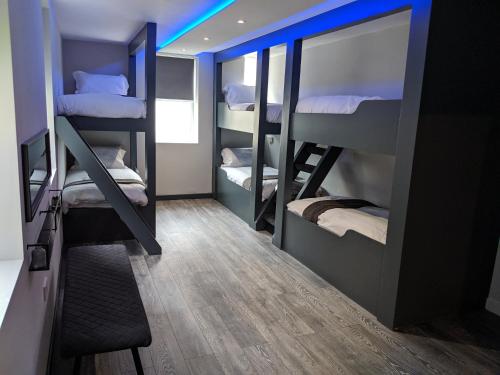 布莱克浦Vibe Holiday Apartments的客房设有三张双层床和蓝色的灯光