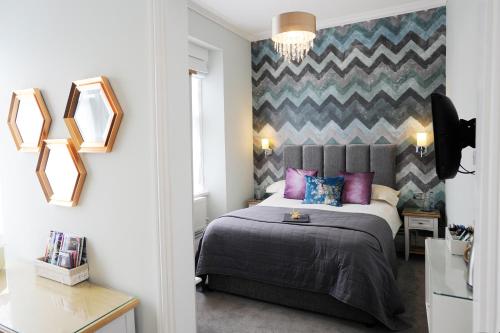 托基克利夫兰2011-2012四星级金奖酒店的一间卧室配有一张特大号床和紫色枕头