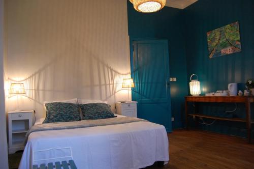 贝尔热拉克Madeleine Bergerac的一间卧室配有一张蓝色墙壁的床