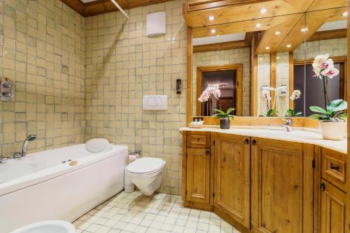 科尔蒂纳丹佩佐拉奎拉酒店的带浴缸、卫生间和盥洗盆的浴室