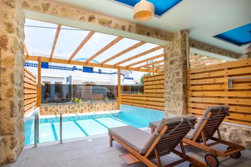 法里拉基沙湾海滩旅馆的一个带两把椅子的庭院和一个游泳池