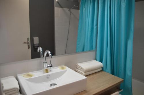 基伯龙Hôtel des Druides的浴室设有水槽和蓝色的浴帘