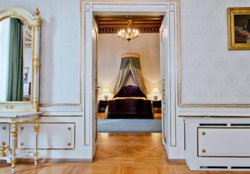 克拉科夫格兰德酒店的走廊上设有一张位于带镜子的房间内的床铺