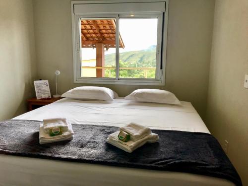 戈亚斯州上帕莱索Vila dos Cristais的一张带两条毛巾的床和窗户
