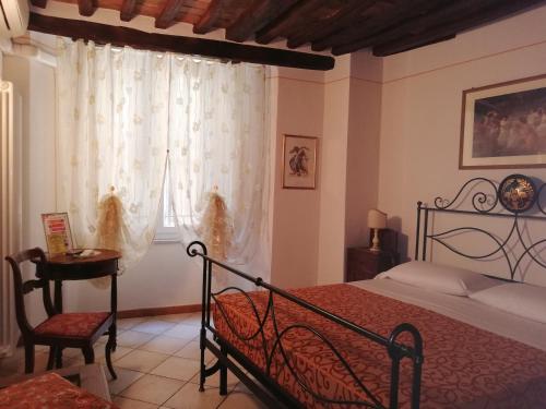 锡耶纳阿尔杜波特住宿加早餐旅馆的一间卧室配有一张床、一张桌子和一个窗户。
