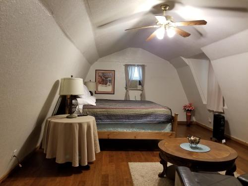 弗雷德里克斯堡Almond Cabin的一间卧室配有一张带吊扇和一张桌子的床。