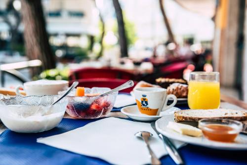 利多迪耶索罗Hotel Residence Mara的一张蓝色桌子,上面有早餐食品和饮料