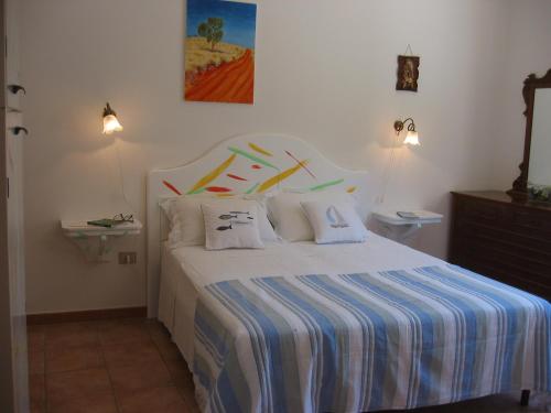 托雷苏达Il Gabbiano的一间卧室配有一张带蓝色和白色条纹床单的床