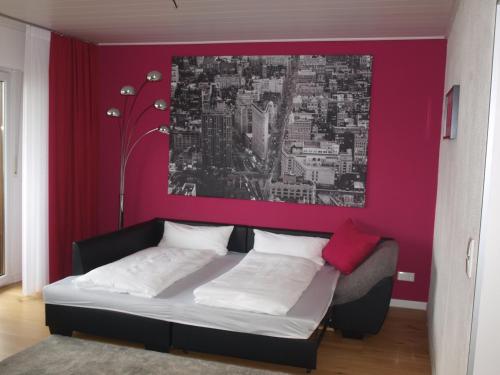 施瓦巴赫SC Apartment - Nürnberg Messe / Fränkisches Seenland的一间卧室配有一张粉红色墙壁的床